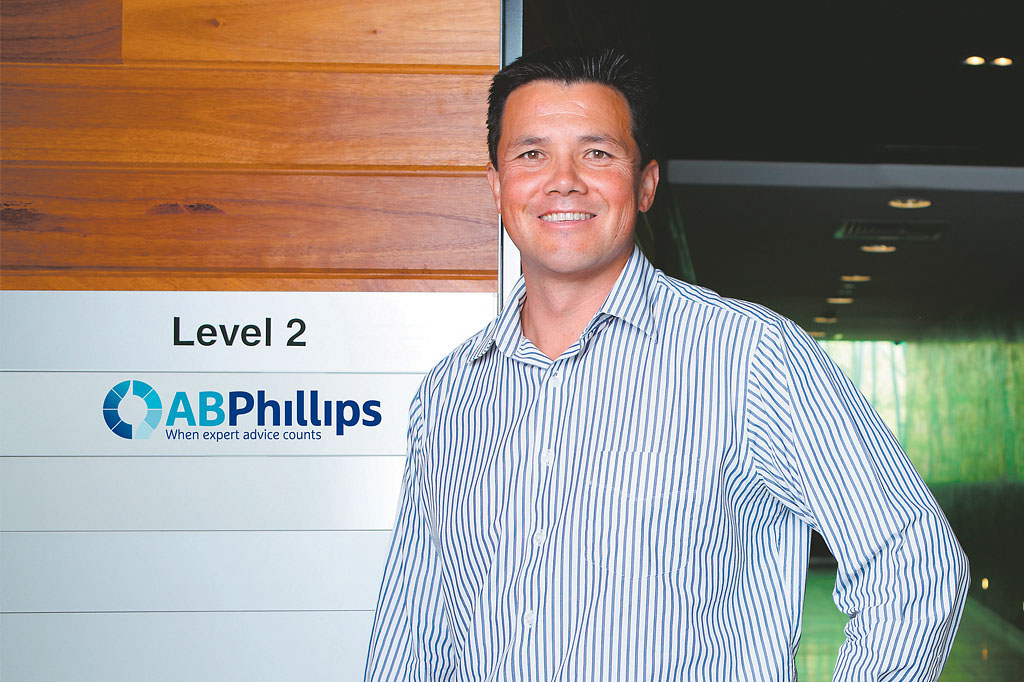 AB Phillips CEO standing beside new corporate logo signage showcasing successful financial services rebrand Melbourne