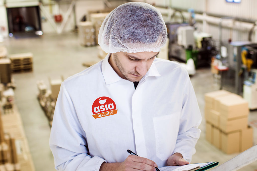 Food manufacturing employee wearing branded Asia Delights uniform showcasing logo design, food branding and FMCG brand identity by Melbourne freelance graphic designer