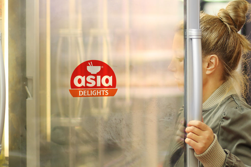 Shopper opening freezer door featuring Asia Delights branding and logo design showcasing retail packaging and FMCG brand identity.