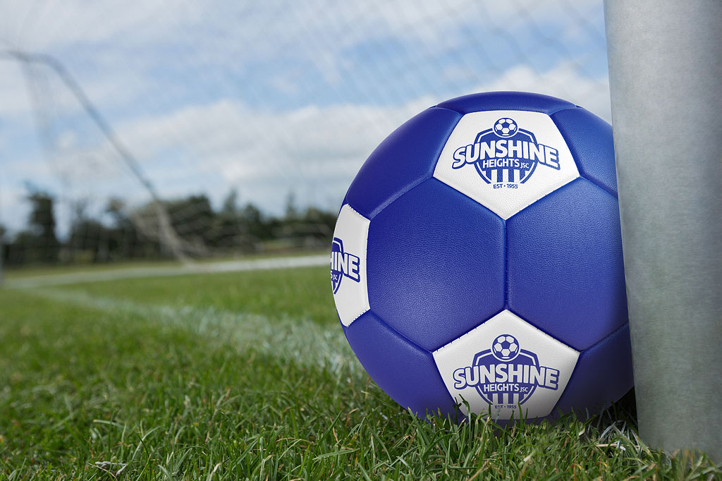 Sunshine Heights Junior Soccer Club branded soccer ball resting on a goal post, showcasing consistent sports branding and logo application across club equipment.